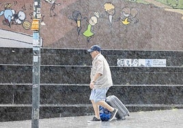 Un hombre camina bajo la lluvia este miércoles por la mañana en la plaza Nestor Barrenetxea de Donostia