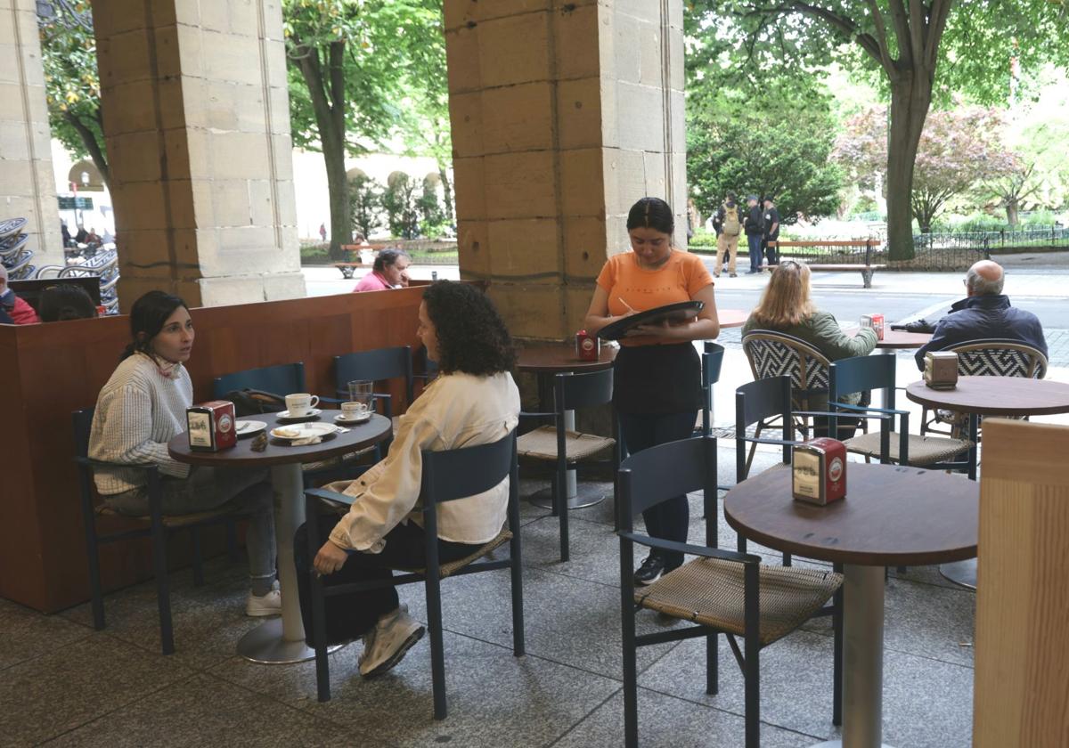 Una camarera atiende varias mesas en un bar del centro de San Sebastián.