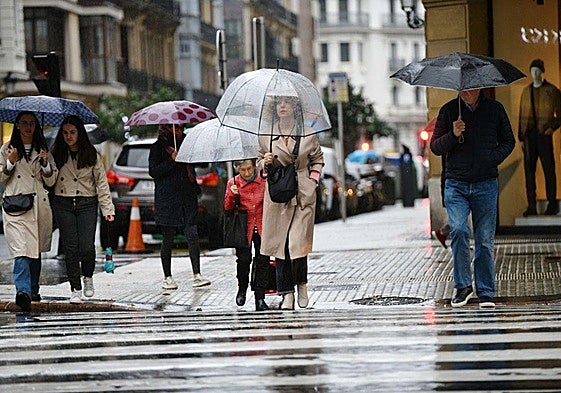 Varias personas bajo el paraguas en un día de lluvia en la Avenida de San Sebastián.