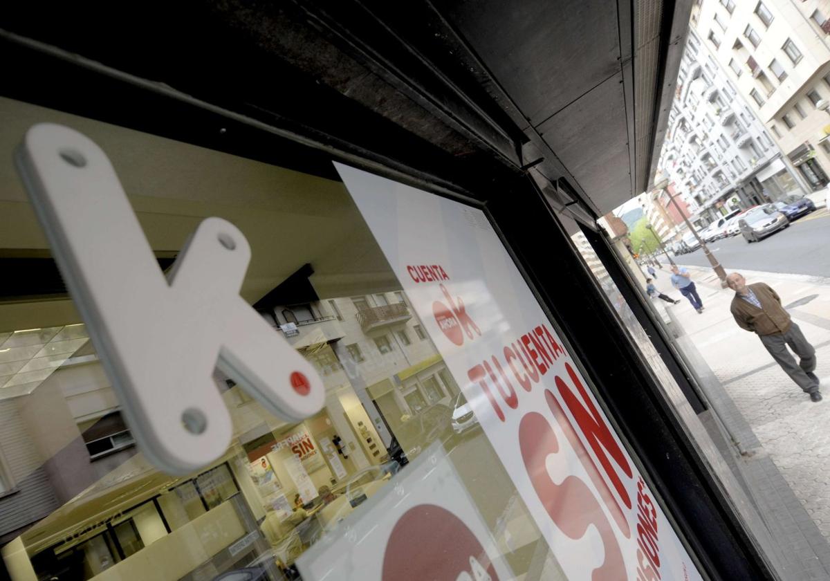 Un hombre camina frente a una sucursal bancaria de Kutxabank.