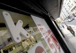 Un hombre camina frente a una sucursal bancaria de Kutxabank.