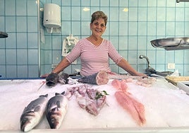 Maite tras el escaparate de la pescadería, desde la que ha fraguado una gran relación con los vecinos.