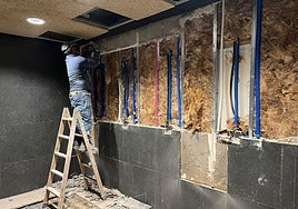 Un trabajador durante la instalación de una ducha.