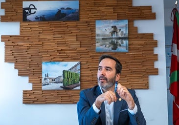 Javier Hurtado, durante la entrevista en una sala con imágenes de atractivos turísticos, entre ellos el Peine del Viento de Donostia.