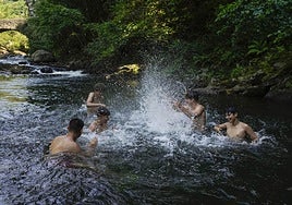 Varios jóvenes se refrescan en Andoain ante el fuerte calor de este lunes.