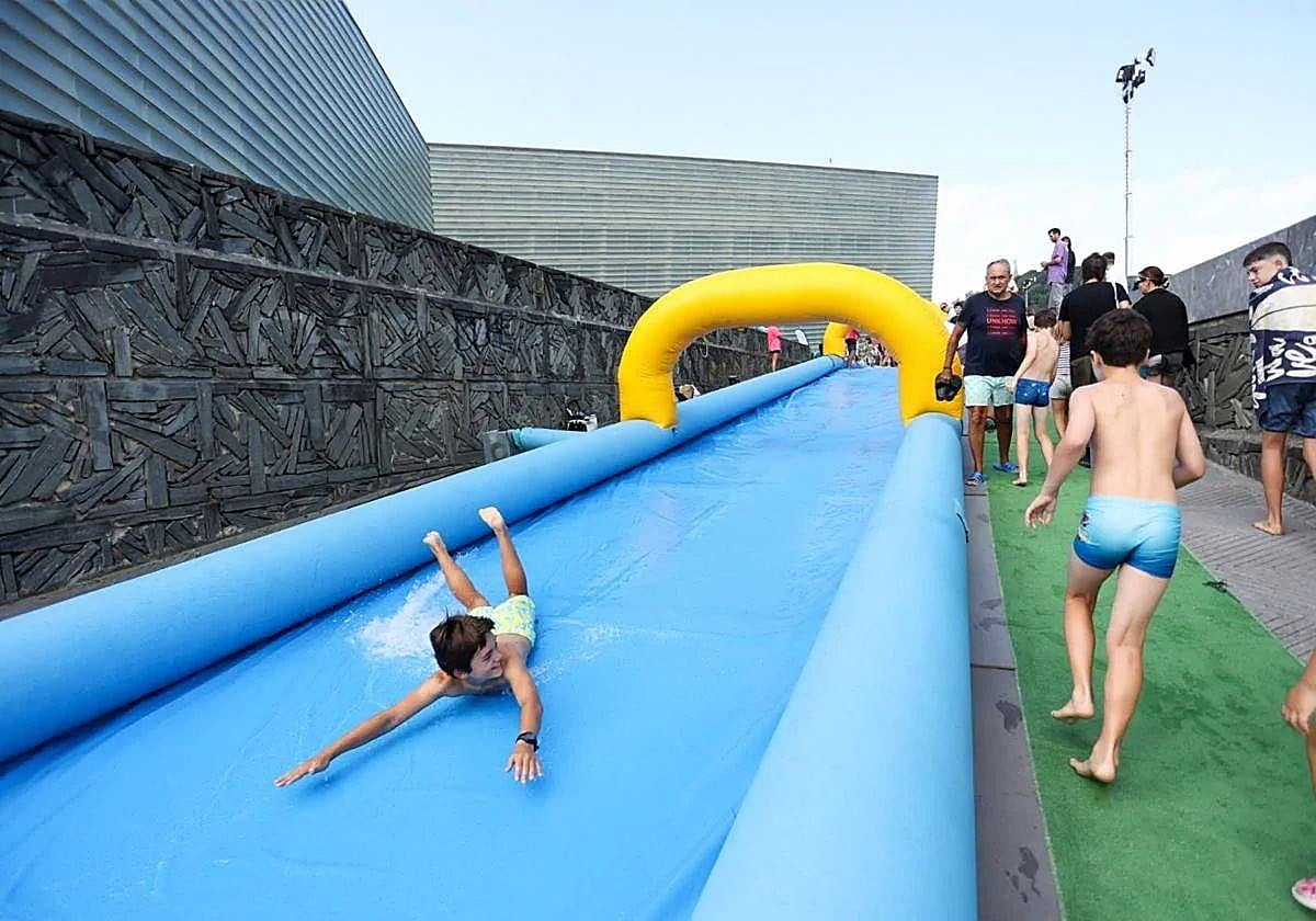 Un txiki se divierte bajando por el tobogán acuático del Kursaal.