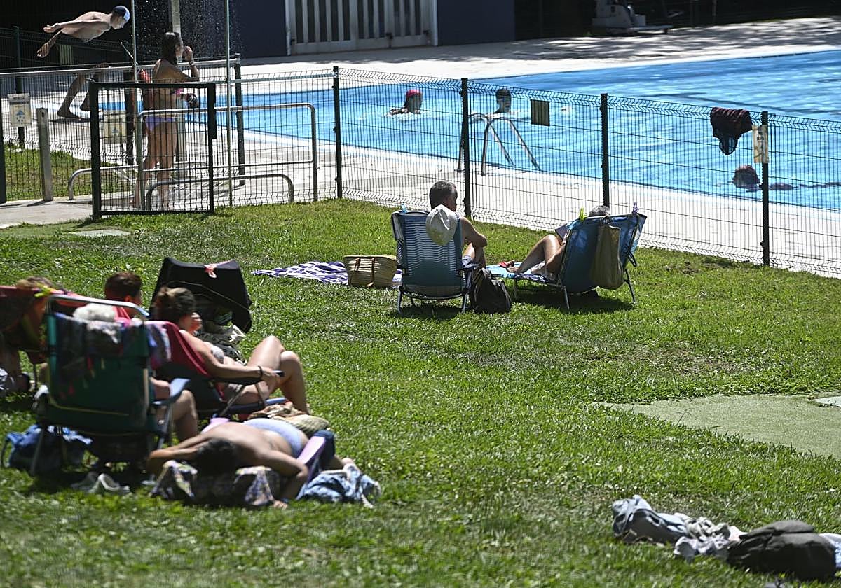 Varias personas toman el sol y se refrescan en la piscina de Urretxu.