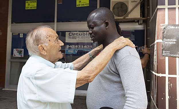 Un hombre se despide de un migrante en la plaza Cofradías.