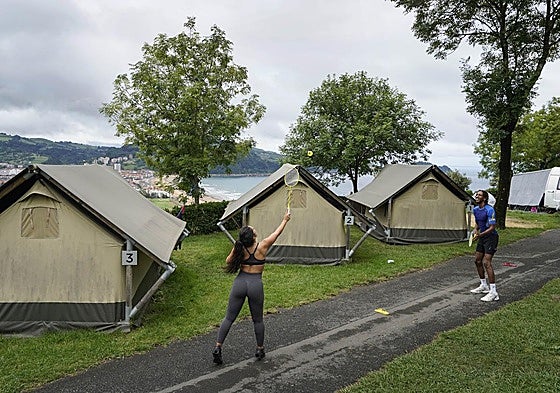 Dos jóvenes juegan a bádminton en el jardín del camping situado en Zarautz.