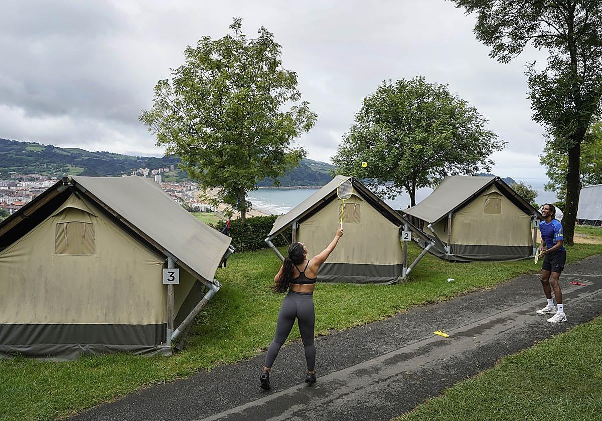 Dos jóvenes juegan a bádminton en el jardín del camping situado en Zarautz.