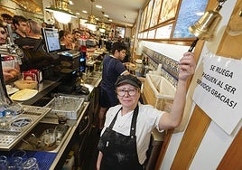 Coro López Iñarra, encargada de la Mejillonera, tocando su icónica campana en el bar.