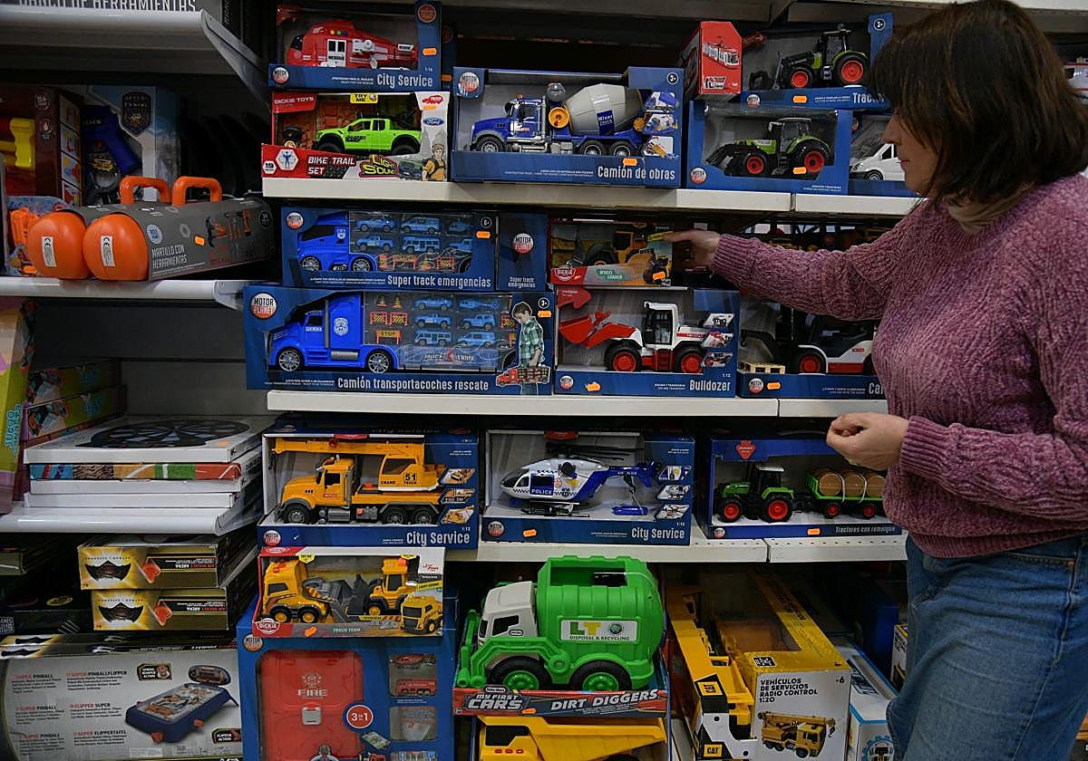 Una empleada selecciona un producto en una juguetería de San Sebastián.