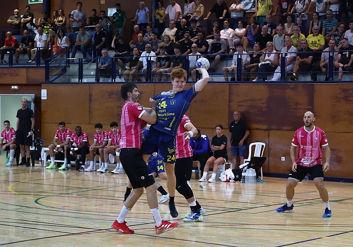 Mielczarski busca el tiro mientras es agarrado por un rival.