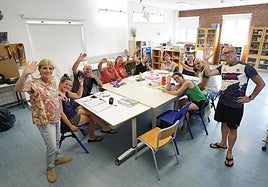 Los nueve alumnos del barnetegi familiar saludan sentados, con sus profesores Elena y Juanmi de pie, en la eskola txikia de Aduna