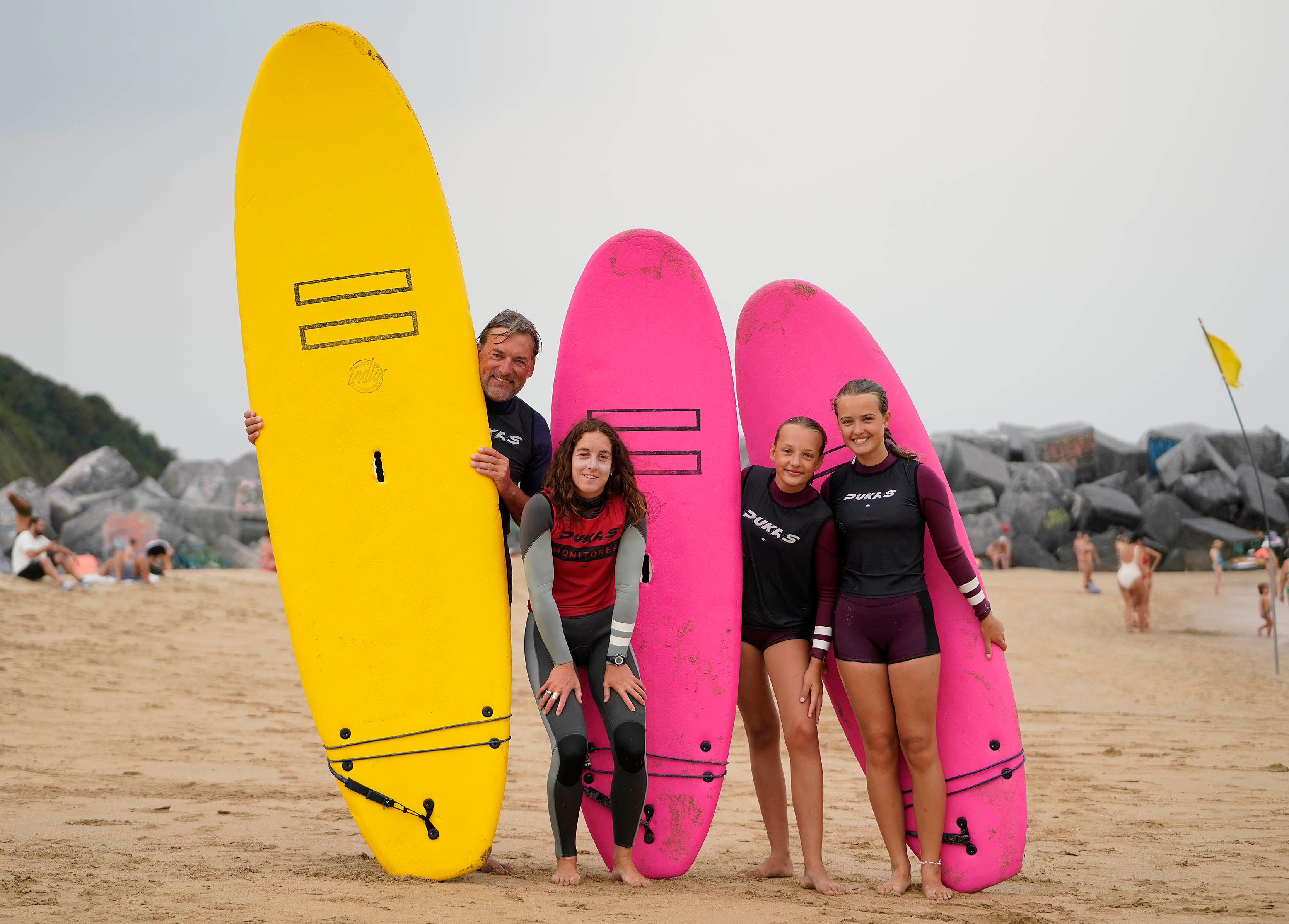 De Vries Meno y sus hijas Ana y Sofía (a la derecha) posan con las tablas de surf junto a la monitora Andrea Larretxea.