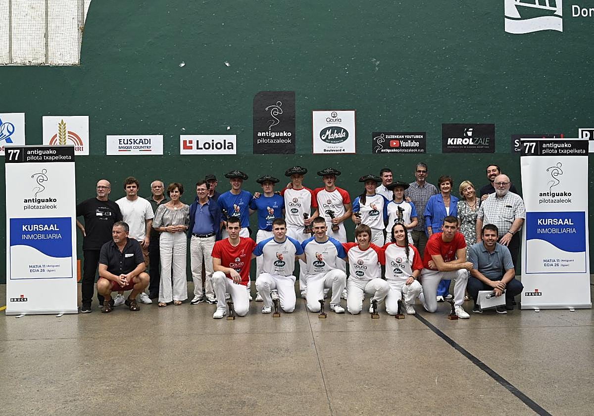 Los finalistas posan con sus trofeos y txapelas junto a autoridades y patrocinadores en el frontón de El Antiguo.
