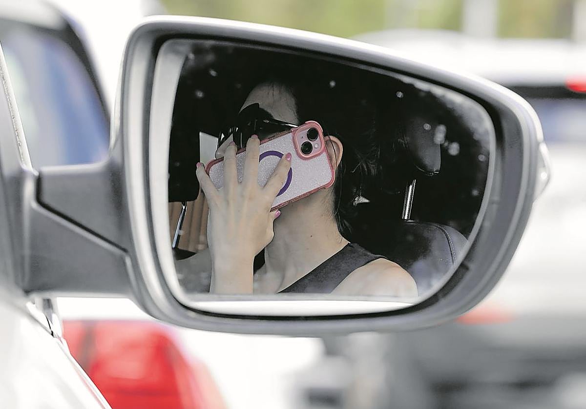 Una mujer habla por el teléfono móvil mientras conduce en Irun.