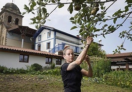 Anne sujeta una rama de un manzano en el huerto junto al restaurante que capitanea.