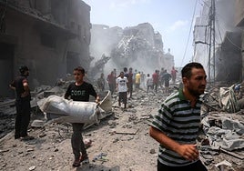 Población de Gaza caminando entre sus escombros causados por el conflicto.