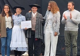 Jone Arriaran eta German Aranburu, txapelak eta saria jasotzen udaleko ordezkarien eskutik.