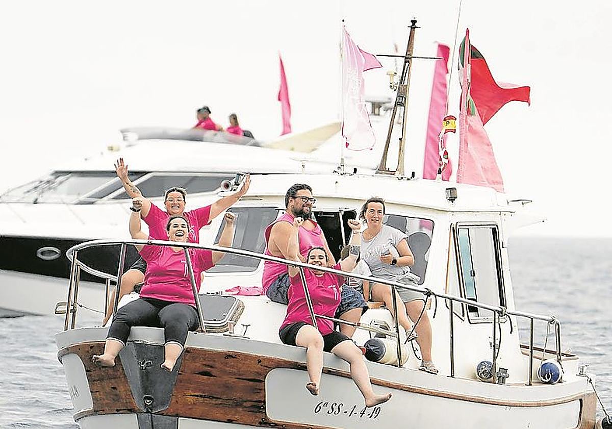 Imagen principal - Arriba, aficionadas de San Juan animan a los suyos desde un barco en la bahía. Debajo, los remeros de Urdaibai se abren paso en la rampa del muelle. Y aficionados de Getaria animan a los suyos en el Muelle.
