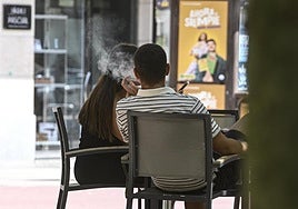 Una pareja fuma en una terraza en Beasain.