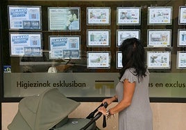 Una mujer pasa por delante del escapate de una inmobiliaria en Arrasate.