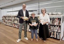 Eneko Goia, Grabriela Cendoya y Susana Soto, posan en la biblioteca del Museo San Telmo, junto al fondo de fotolibros GCBC.