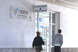 Una madre y su hijo pasan por la entrada a Osatek, en el Hospital Donostia.