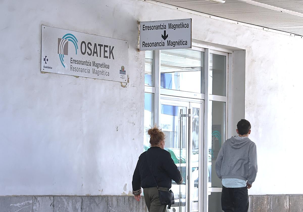Una madre y su hijo pasan por la entrada a Osatek, en el Hospital Donostia.