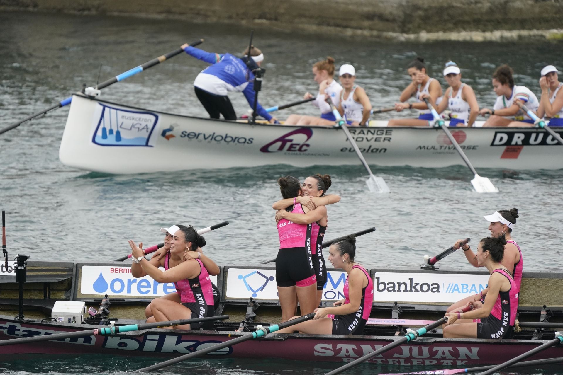 Las remeras de San Juan celebran la segunda posición con Donostiarra, primera, al fondo en Bermeo.