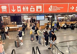 Viajeros en la estación de autobuses de San Sebastián, con la cafetería al fondo.