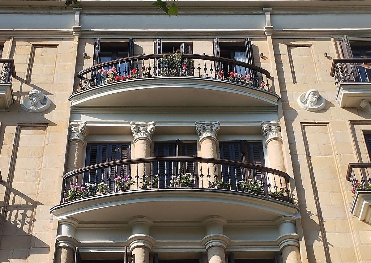 Imagen secundaria 1 - Torre octogonal en el chaflán, con óculos, balaustrada y cornisas molduradas. El mirador de hormigón armado funciona como bisagra entre atmósferas urbanas. Debajo, balcones curvos en el centro de la fachada a Okendo, una unidad compositiva que agrupa tres alturas y ordena el alzado desde dentro.