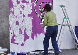 Una mujer pinta un mural con motivo de las celebraciones del Día Internacional de la Mujer del 8 de marzo.