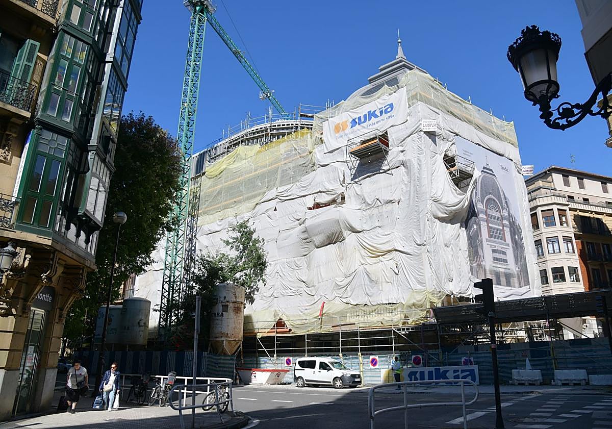 Imagen principal - Las fachadas del edificio permanecen cubiertas con lonas. Debajo, detalle de la cúpula y el levante que se ha construido para el futuro hotel.