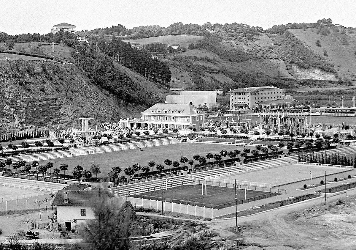 Imagen principal - Campos de deporte de Anoeta con las piscinas al fondo y el merendero Xanti en primer plano, en los años 50. Debajo, maqueta de 1928 del Stadium de Ramón Cortázar.