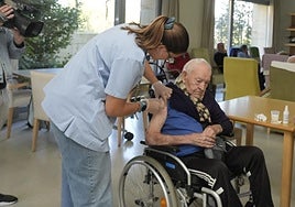 Una enfermera vacuna a un usuario de una residencia.