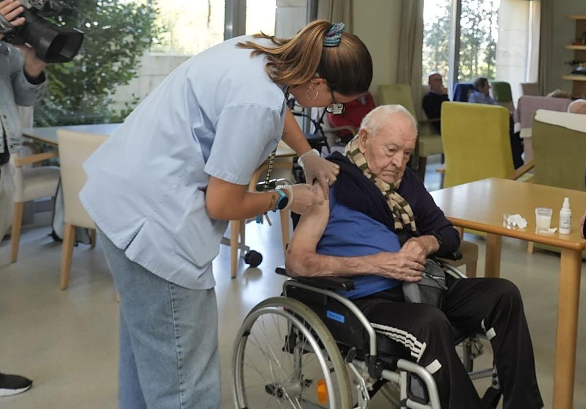 Una enfermera vacuna a un usuario de una residencia.