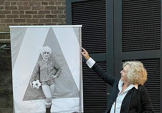 Azkarate, con su inseparable cámara, junto al cartel de la exposición.