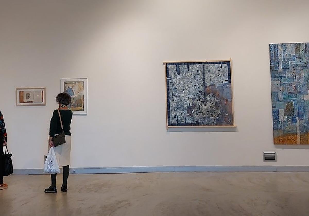 Bi bisitari  Iñaki Zabala 'Ali' artista azkoitiarraren erakusketaz gozatzen.