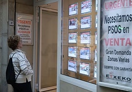 Una mujer observa una inmobiliaria que solicita pisos en venta y en alquiler en Donostia.