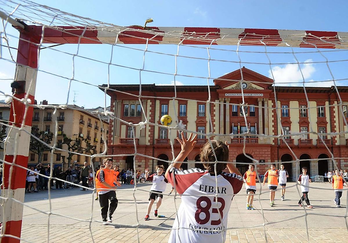 Varios niños juegan a balonmano en una actividad del deporte escolar.