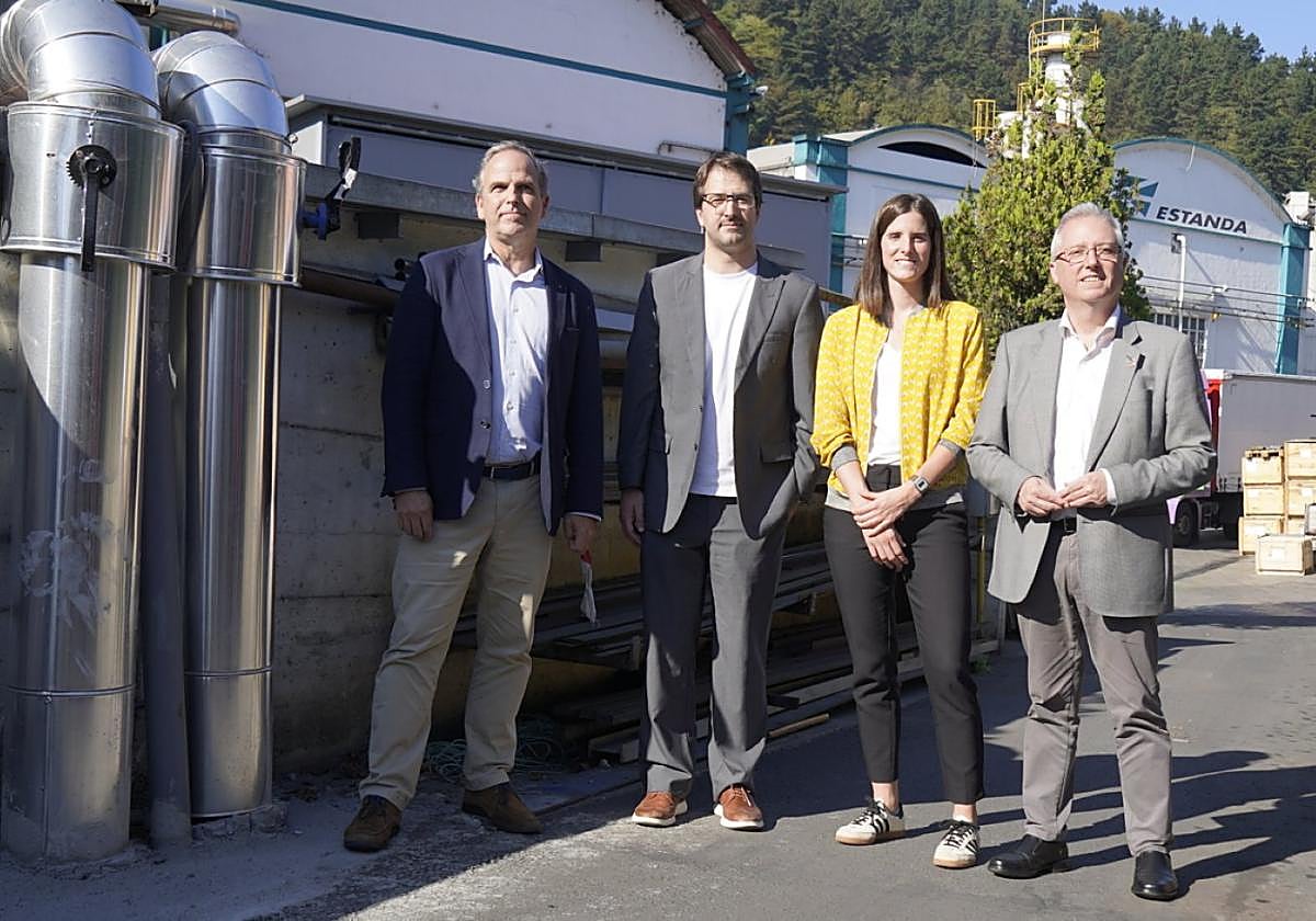 Responsables del proyecto posan junto a los tubos del sistema de District Heating instalados en Estanda.