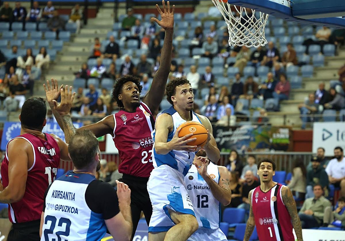 Lance Terry, el mejor ayer, penetra a canasta superando a Kelly.