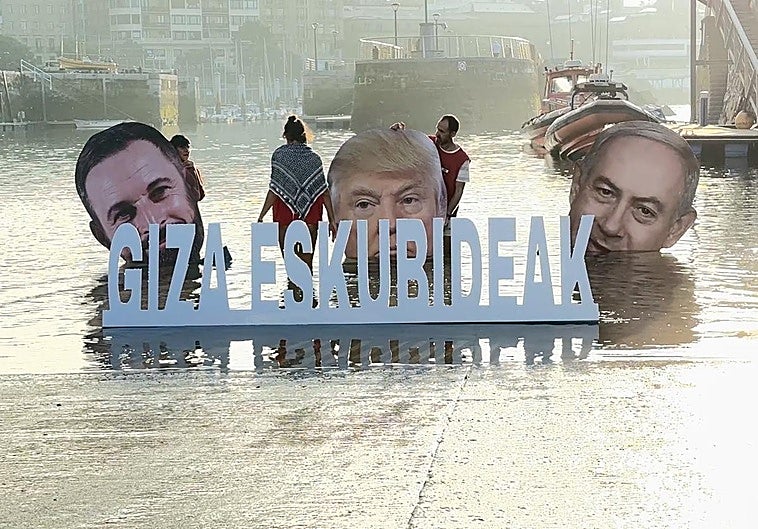 Las cabezas Abascal, Trump y Netanyahu tras un letrero en defensa de los derechos humanos.