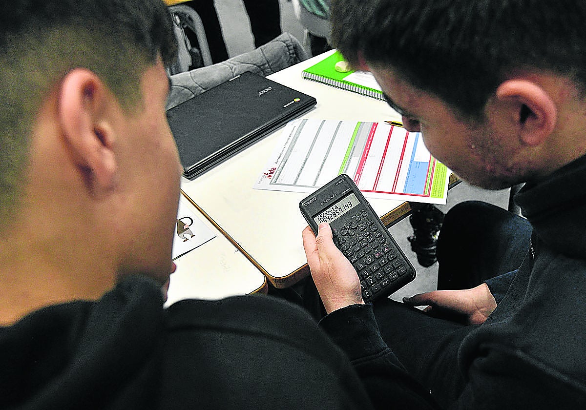 Dos alumnos de Secundaria comprueban con una calculadora el resultado de un ejercicio de matemáticas.