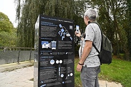 Un hombre escanea el código QR que da información sobre uno de los siete edificios.