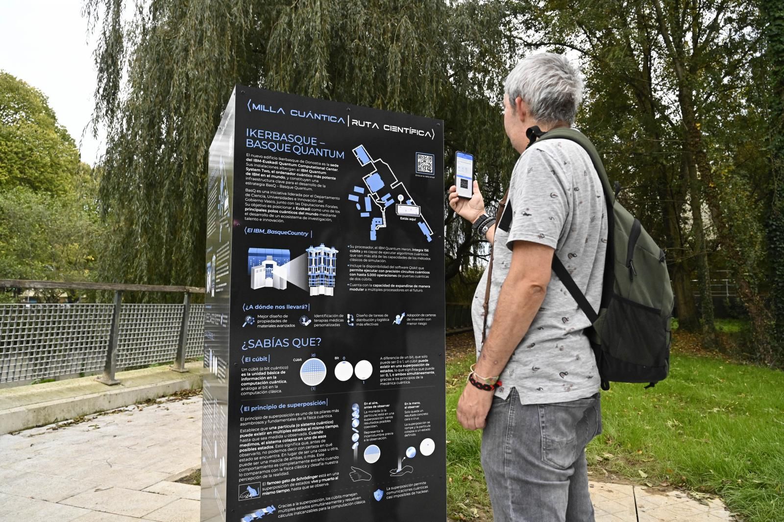 Un hombre escanea el código QR que da información sobre uno de los siete edificios.