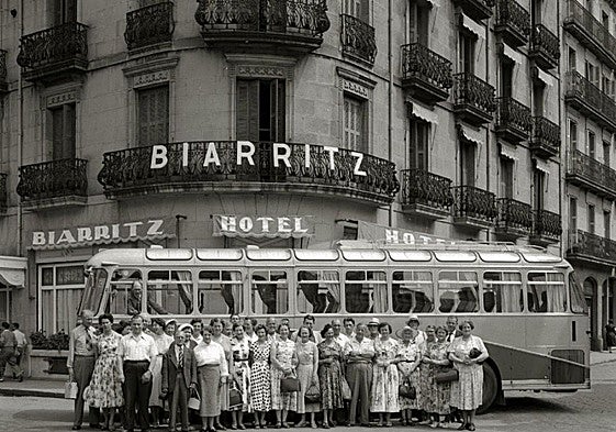 Turistas que parecen salidos de una viñeta de Sempé o una película de Tati, ante el hotel.