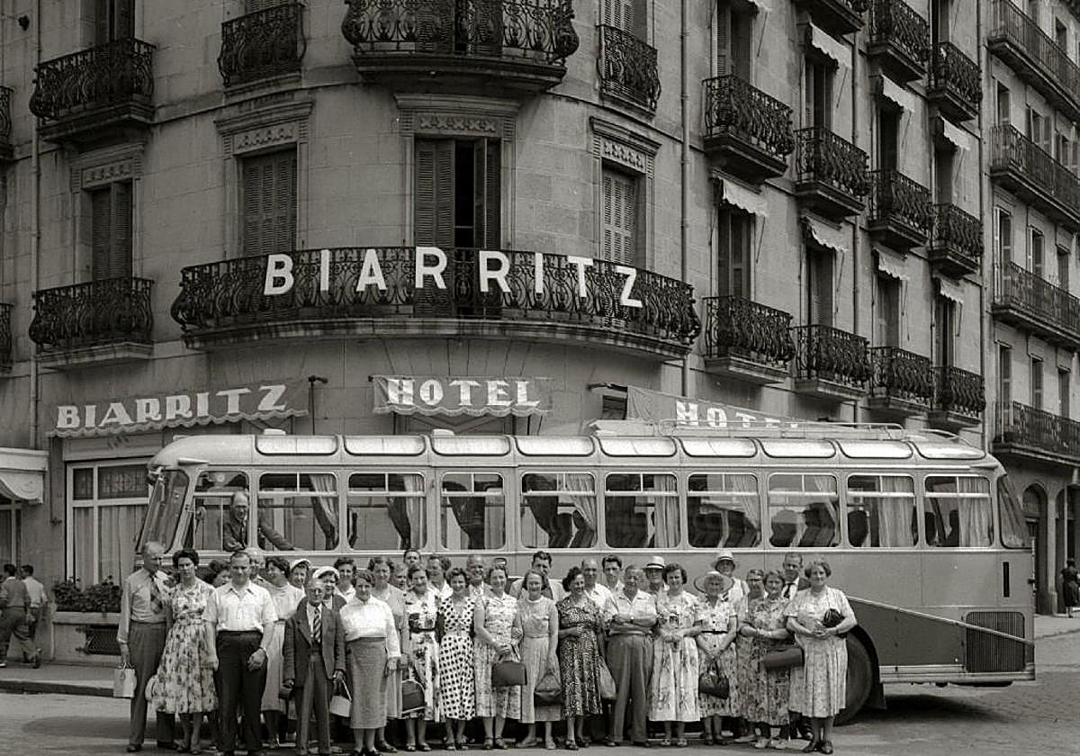 Turistas que parecen salidos de una viñeta de Sempé o una película de Tati, ante el hotel.